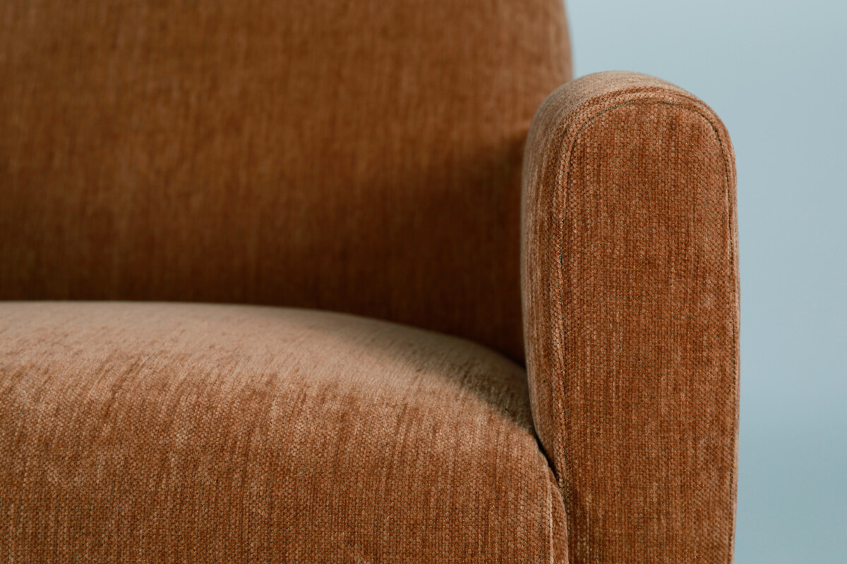 Leona-nojatuolia saa kauniin ruskean ja vaaleanharmaan sävyissä. Nojatuolissa on puiset jalat.