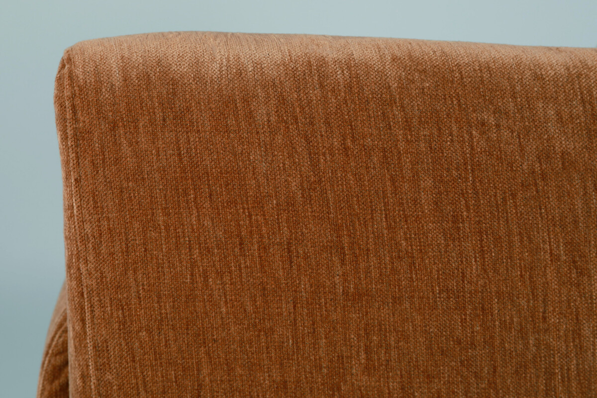 Leona-nojatuolia saa kauniin ruskean ja vaaleanharmaan sävyissä. Nojatuolissa on puiset jalat.